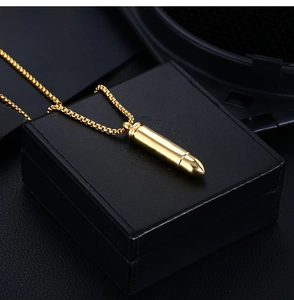 Vue détaillée du pendentif balle dorée sur boîte cadeau avec finition polie miroir