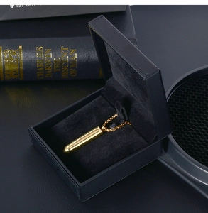 Détail du collier pendentif balle dorée présenté dans un élégant coffret cadeau en velours noir