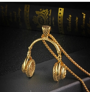 Vue détaillée d'un collier pendentif casque doré avec texture tissée sur boîte cadeau noire