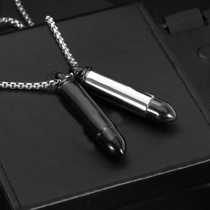 Collier à pendentifs balles en argent poli et noir sur une boîte noire texturée élégante
