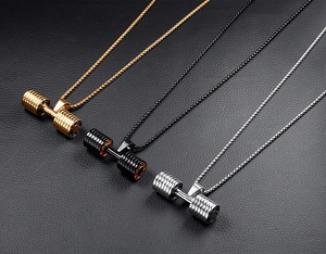 Detailed macro view of barbell pendants in gold, black and silver on leather background
