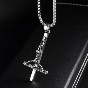 Macro view of vintage stainless steel inverted cross pendant with crucifix and box chain