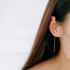 Détail de boucles d'oreilles minimalistes à longue chaîne plaquées or 18 carats