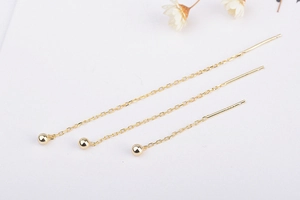 Détail de boucles d'oreilles traversantes en titane plaqué or 18K avec perles