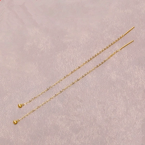 Détail de boucles d'oreilles traversantes en titane plaqué or 18 carats avec billes