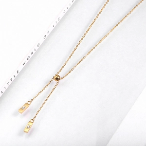 Détail d'un collier lasso doré ajustable avec des pendentifs rectangles en zircone