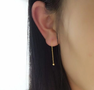 Boucle d oreille pendante en or avec perle montrant le tombé élégant et la longueur