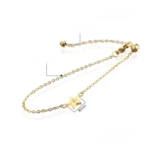 Detailed view of polished golden star pendant with white zircon on stainless steel bracelet