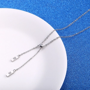Détail du collier en Y argenté avec curseur réglable et deux pendentifs rectangulaires sertis