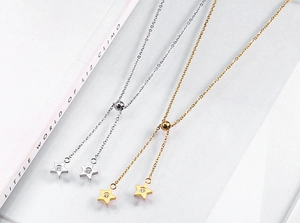 Detailed view of adjustable star pendants with zircon inlay in gold and silver finishes