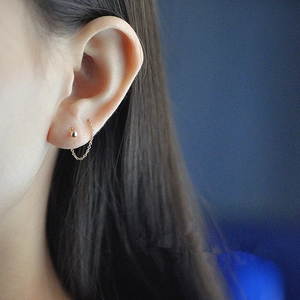 Détail de boucles d'oreilles traversantes en plaqué or 18K montrant la chaîne et la perle