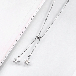 Close-up of adjustable silver star necklace with zircon stones and sliding ball clasp