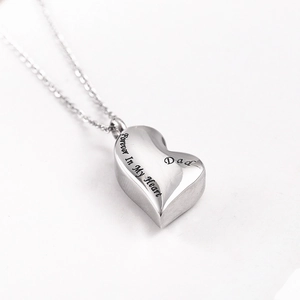 Macro shot of stainless steel heart urn pendant with Forever In My Heart Dad engraving
