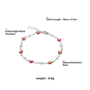 Vue macro du bracelet poli en acier inoxydable avec oeil maléfique et pendentifs croix