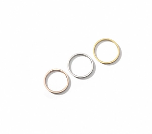 Detailed macro view of three minimalist 18K gold plated stackable rings in various colors