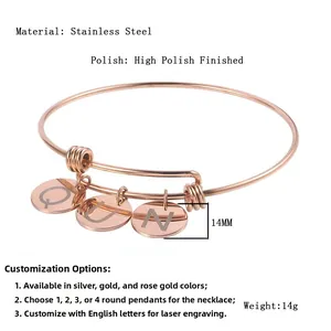 Detailed macro view of three rose gold stainless steel charms engraved with Q, U, N letters