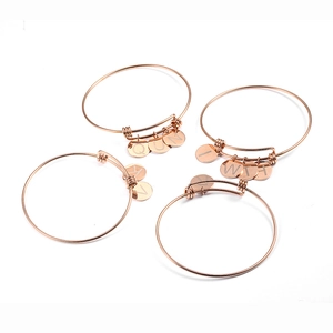 Detailed top view of four adjustable rose gold bracelets with engraved letter charms