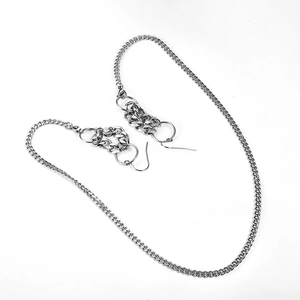 Dettaglio di orecchini ear cuff a catena cubana argento e maglie in acciaio inossidabile
