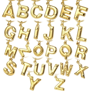 26 golden balloon style initial necklaces with textured studs and snake chains on white background