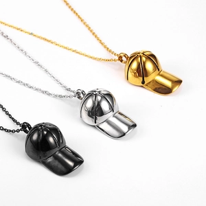 Dettaglio di tre ciondoli a forma di cappello da baseball in oro, argento e nero acciaio