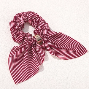 Close-up of vintage red striped fabric hair scrunchie with a gold metallic buckle detail