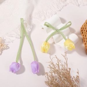 Detalle de accesorios de pelo con tulipanes de satén hechos a mano en lila y amarillo