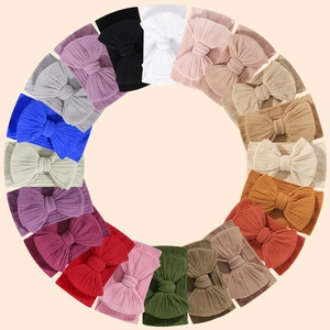 Detailed view of twenty colorful jacquard elastic baby headbands with bow accents