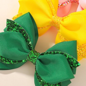 Detailed close-up of colorful grosgrain ribbon hair bows with glittery sequin edges