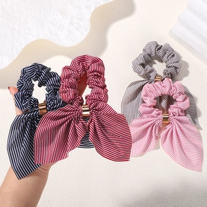 Detail of striped bow hair scrunchies with elegant gold metal buckles in various colors