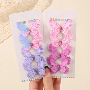 Detail of 3D double-layered glitter butterfly clips with colorful rhinestones and fabric texture