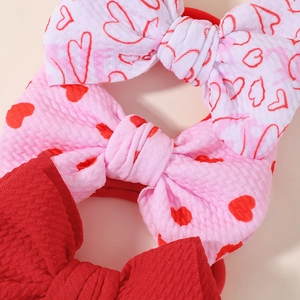 Detail showing red and white heart pattern bows with soft ribbed knit texture
