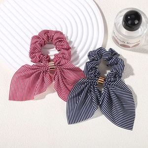 Detail view of red and navy striped bow hair scrunchies with gold metal ring buckles