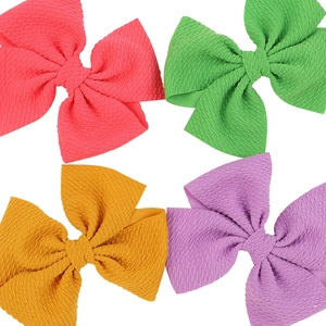 Set di quattro fiocchi colorati per capelli da bambina in rosa, verde, giallo e viola