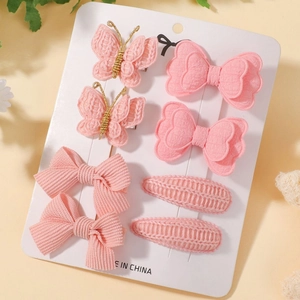 Détail du lot de 8 barrettes roses pour enfants avec nœuds et papillons sur carte