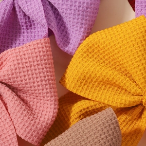 Detail of waffle-weave fabric bows in vibrant lavender, coral pink and yellow colors