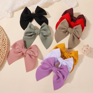 Multi-color waffle texture bow hair clips set for girls displayed on a warm beige background
