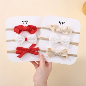 Detail of soft nylon baby headbands with red rib and white lace bows for infants