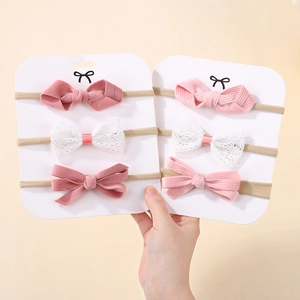 Detail of soft nylon baby headbands with corduroy and lace bows in pink tones