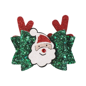 Detail of Christmas bow hair clip with Santa Claus face and red sequin antlers