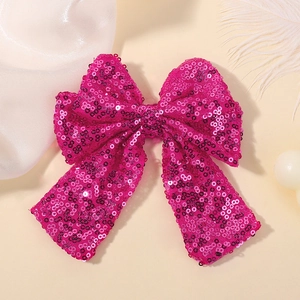 Detail of hot pink sequin hair bow for girls with sparkling textures and elegant ribbons