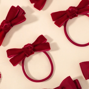 Détail du set d'accessoires cheveux en velours rouge avec nœuds et élastiques