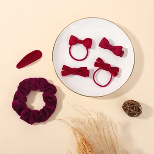 Vue à plat de nœuds rouges et chouchou en velours sur une assiette décorative