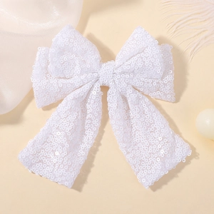 Detail of white sequined bow hair clip with ribbons for girls' party accessories