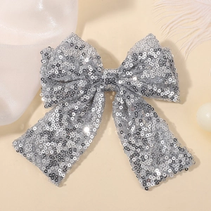 Macro shot of silver sequin bow hair clip with detailed hand-stitched mesh and glitter texture