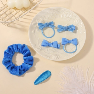 Détails d'un ensemble de nœuds à cheveux en velours bleu clair dans un plat en céramique