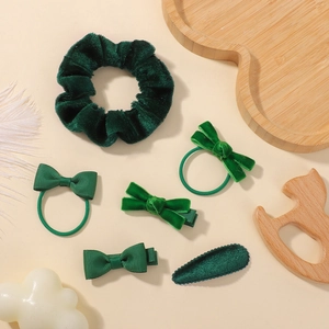 Détail de barrettes à nœuds et chouchous en velours vert forêt pour filles