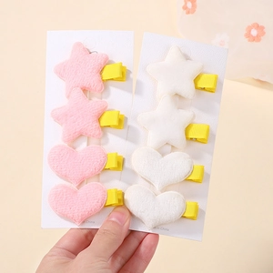 Dettaglio di fermagli per capelli in peluche a stella e cuore con nastro giallo lucido