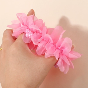 Detailansicht eines rosa Chiffon Blumen Haargummis mit Zierperlen und Tüllblütenblättern