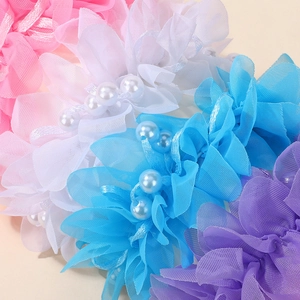 Makroaufnahme von bunten Chiffon-Blumen-Haargummis mit eleganten Kunstperlen-Details