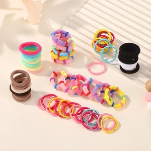 Vue à plat d'élastiques à cheveux colorés aux tons macaron et textures en tissu doux
